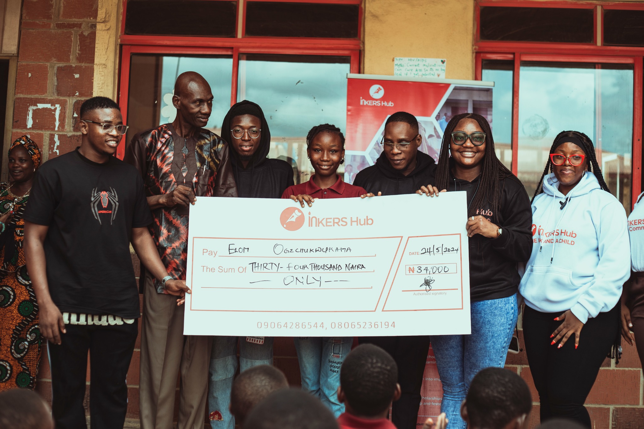 Inkers Hub team presenting a scholarship cheque to a student